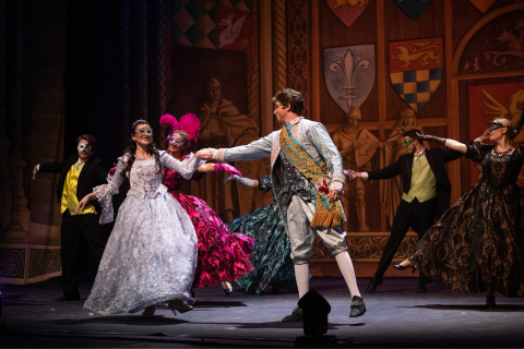 a group of people on a stage dressed in costume.